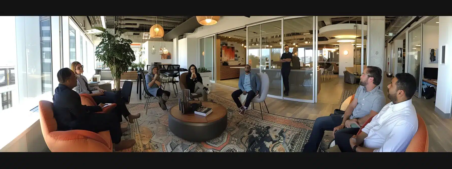 a diverse group of professionals engaged in a lively discussion in a modern, open-concept office space.